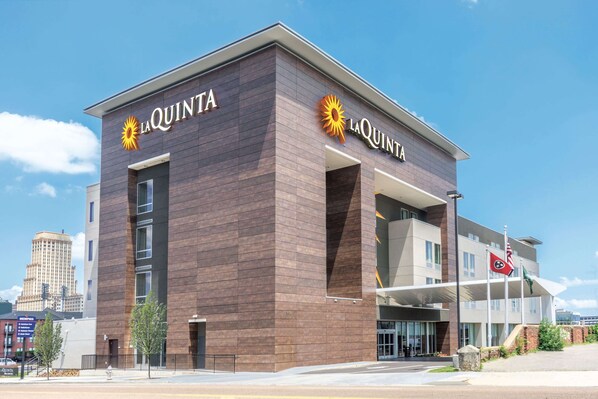 Et moderne hotel med et tydeligt 'La Quinta'-skilt, der har en sols logo.