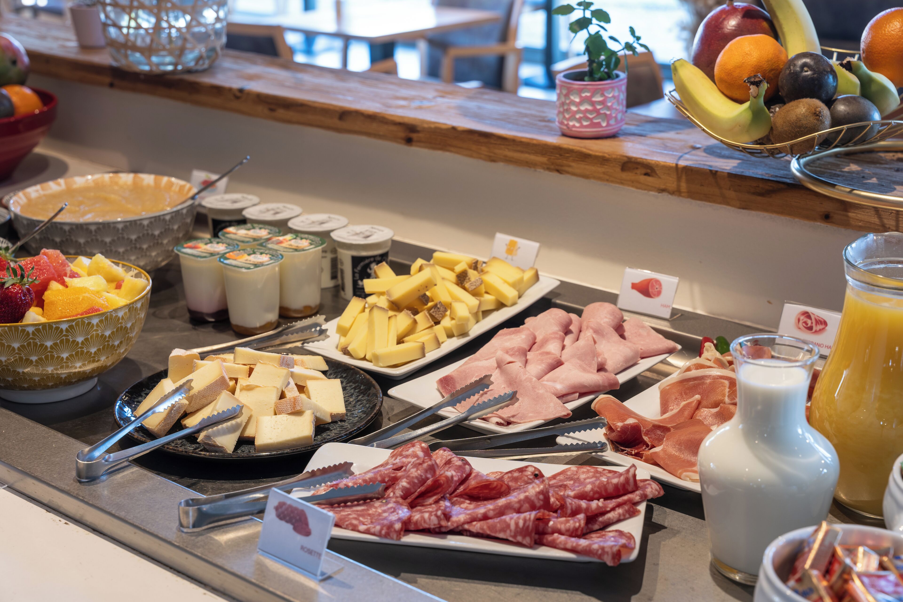 En buffé med ett varierat utbud av mat, inklusive frukt, ostar, kött och drycker.