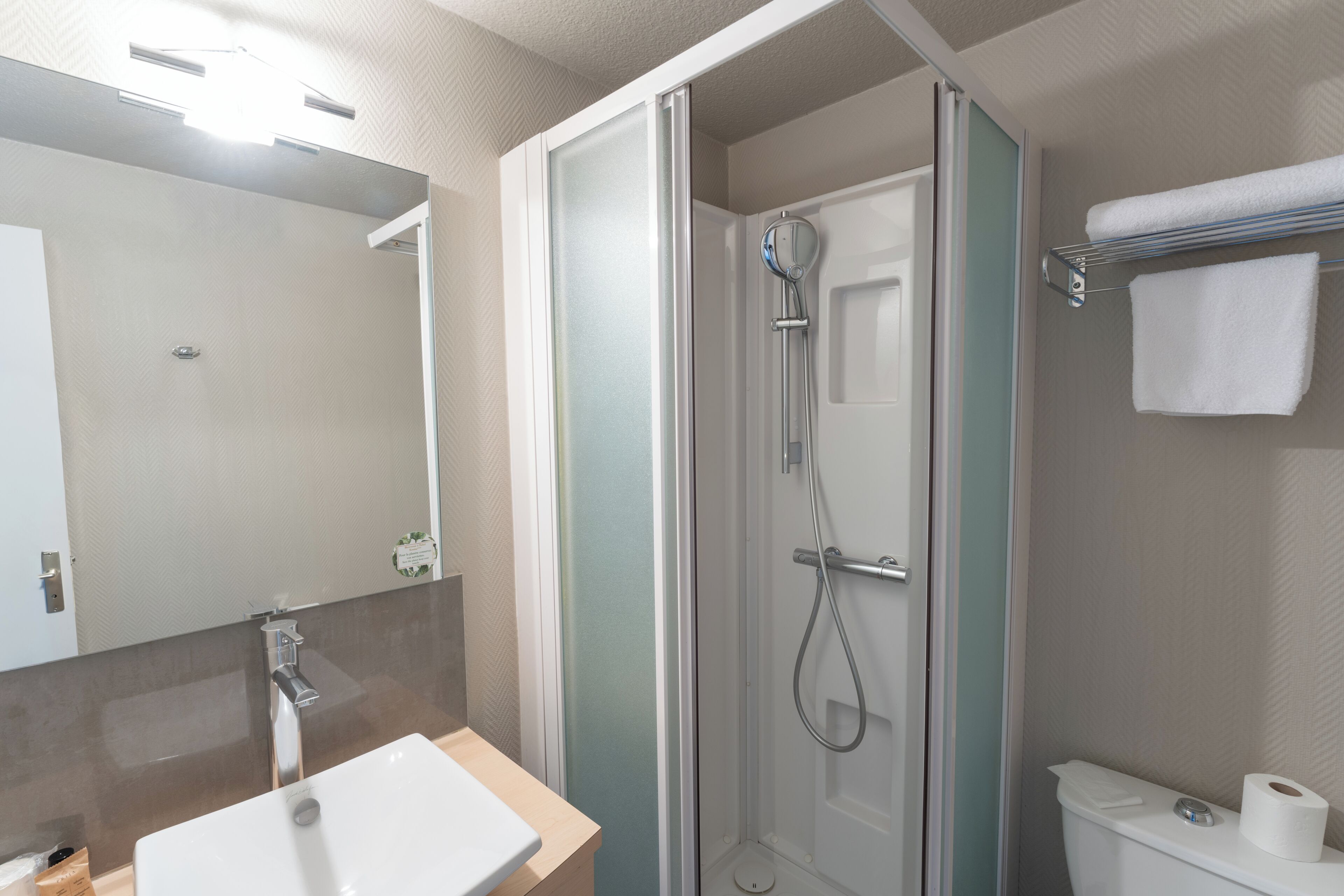 Un baño con ducha, inodoro y lavabo.