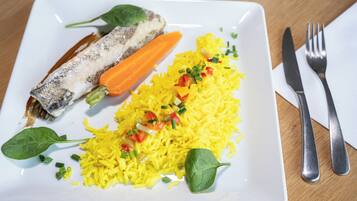 Un plato de comida con arroz, verduras y pescado.
