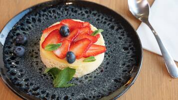 A dessert on a textured plate with a spoon and napkin beside it.