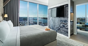 A modern hotel room with a large bed, a city view, a map on the wall, and a television. - Canopy by Hilton Washington DC The Wharf (Washington)