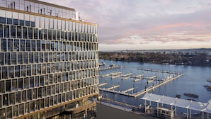 Ein modernes Gebäude mit Glasfassade und Blick auf eine Marina mit Anlegestellen und Booten.