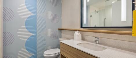 A modern bathroom with a toilet, a sink, and a mirror.