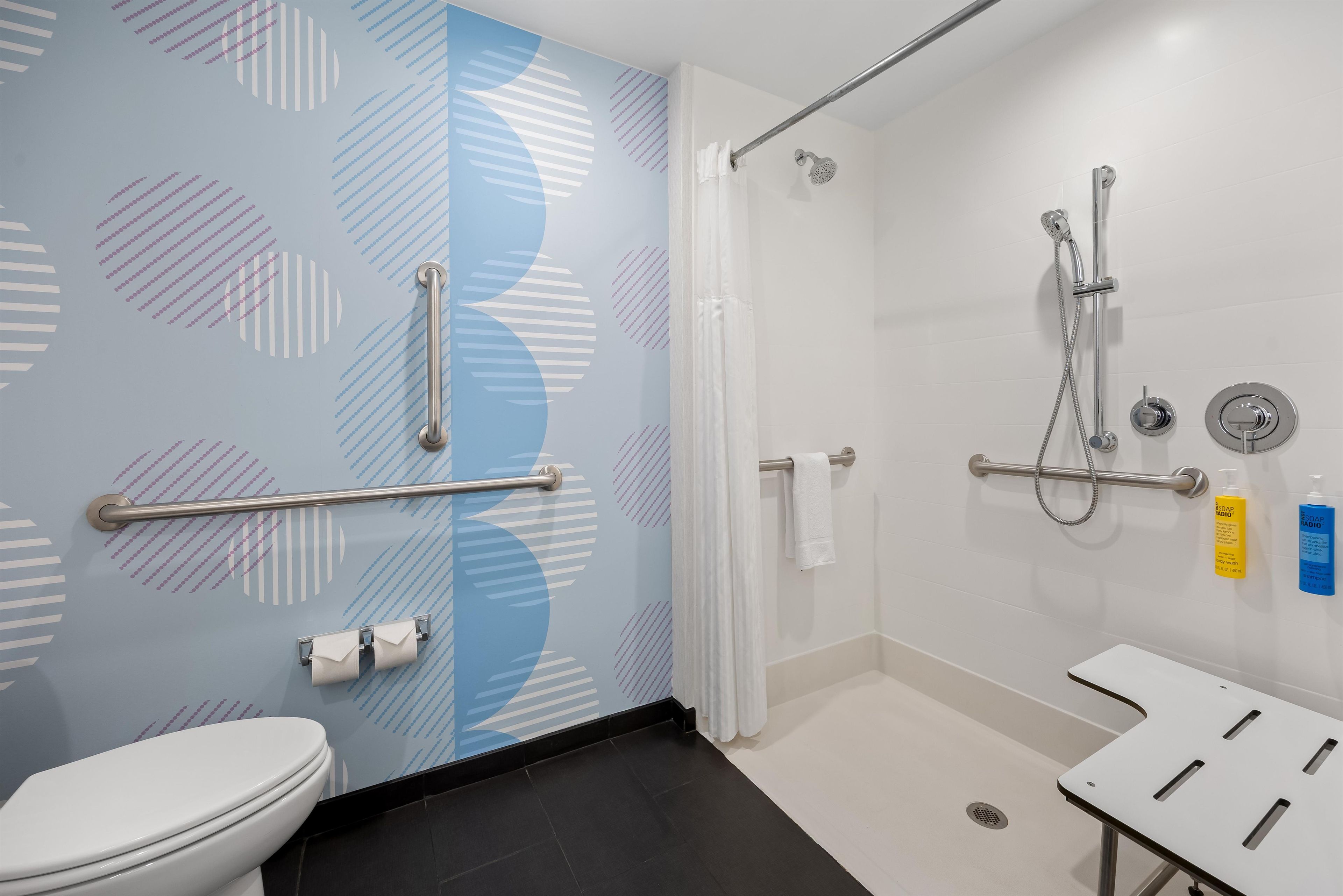 A bathroom with a toilet, a shower area, and a sink.