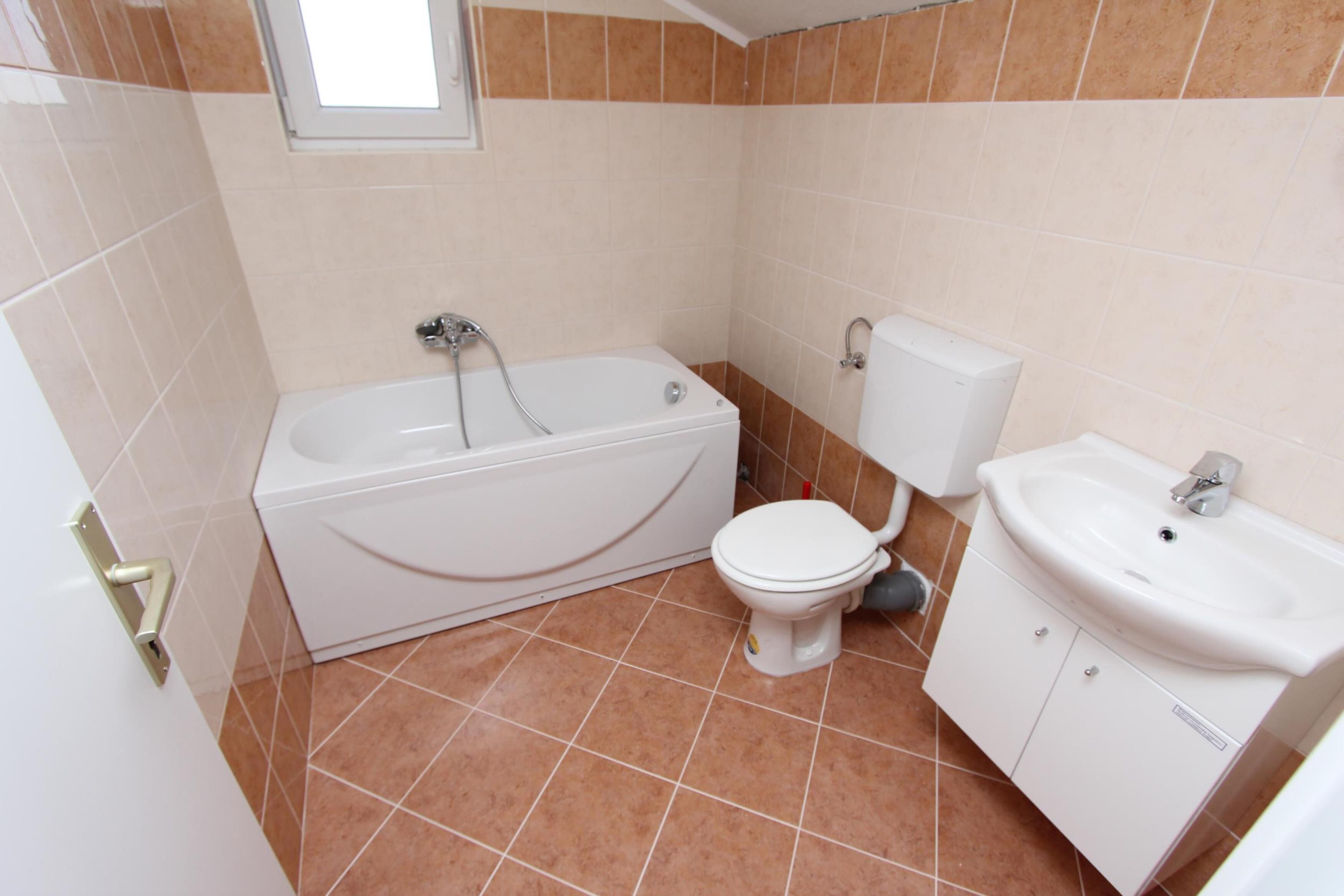 A bathroom with a bathtub, toilet, and sink.