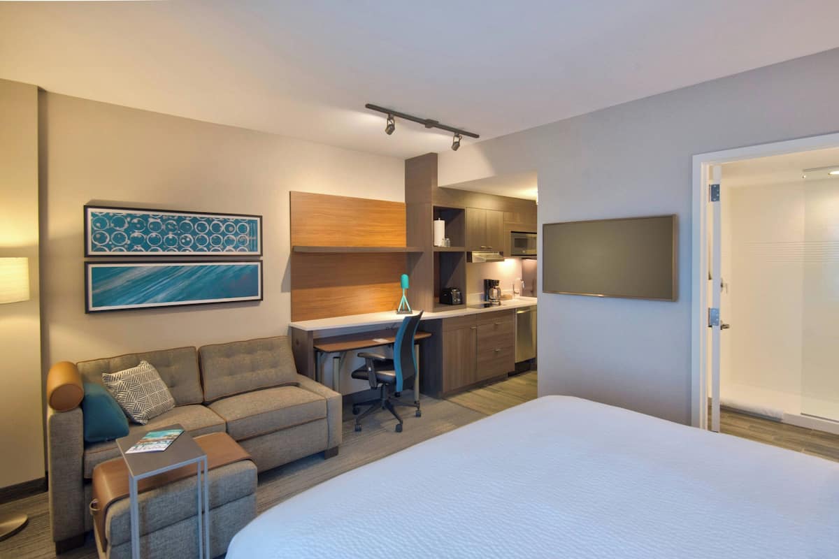 Une chambre d’hôtel comprenant un lit, un canapé, un bureau et une kitchenette.