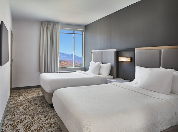 A hotel room with two beds, a large window with a mountain view, a flat-screen TV, and a carpeted floor. - SpringHill Suites by Marriott Moab (Moab)