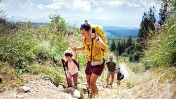 Una persona caminando con un niño y una mochila.
