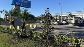 Bordje voor Riverview Boutique Inn & Suites, met een parkeerplaats en een gebouw op de achtergrond.