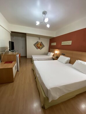 A hotel room with two beds, a desk with a TV, a wardrobe, and a ceiling fan. - Liber Hotel Nova Serrana (Nova Serrana)