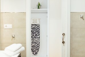 Un baño con un perchero, una repisa con un adorno y un inodoro.