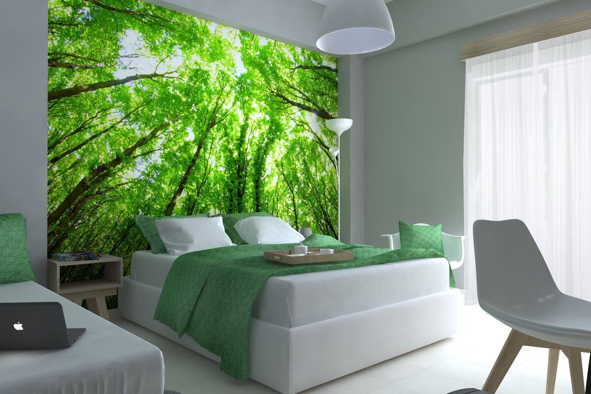 A modern bedroom with a large bed, a desk, and a chair.