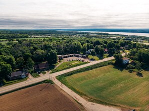 Luchtbeeld van een landelijk gebied met een motel, een parkeerplaats en omliggende velden.