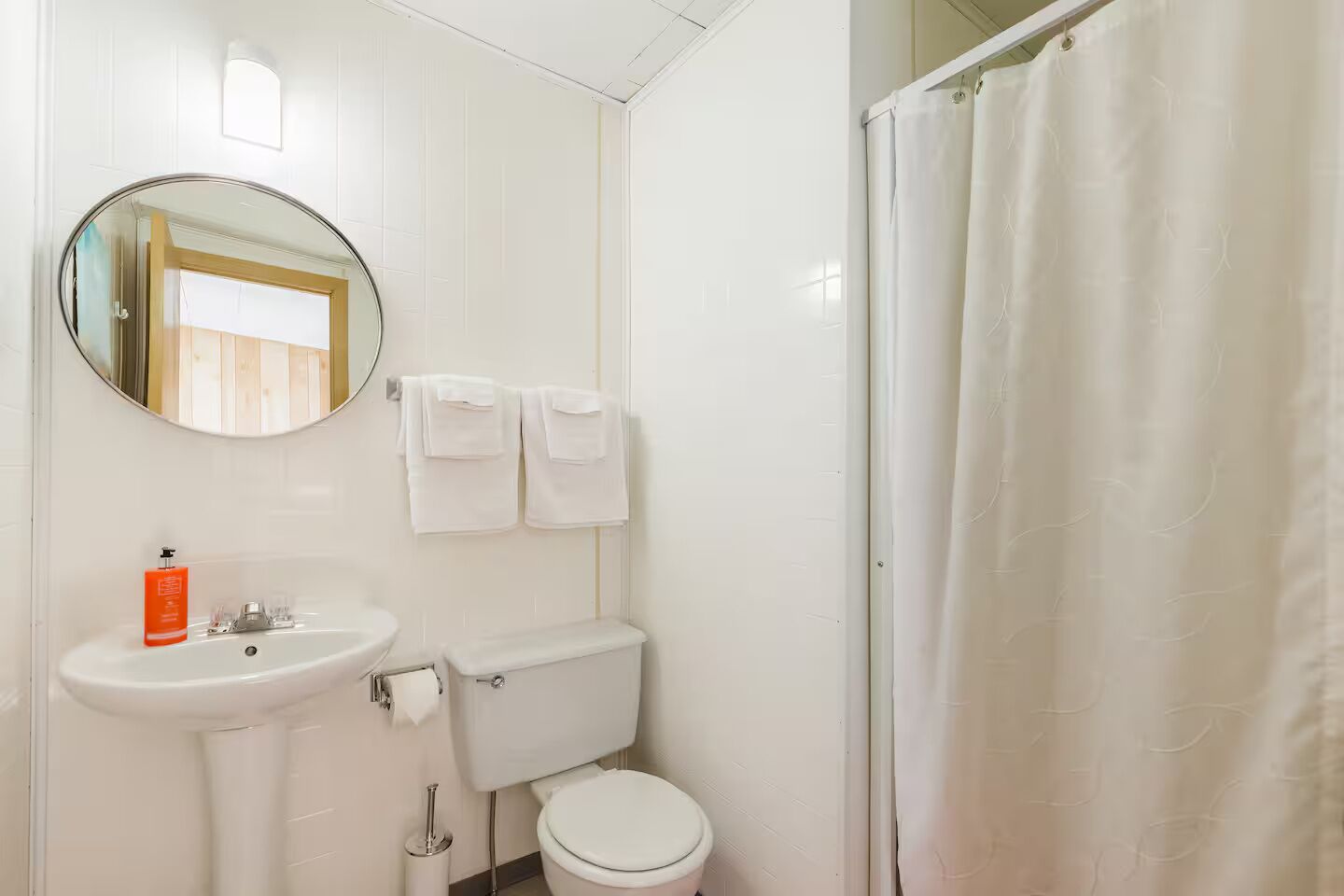 Een badkamer met een wastafel, toilet en douchegordijn.