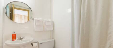 Een badkamer met een wastafel, toilet en douchegordijn.