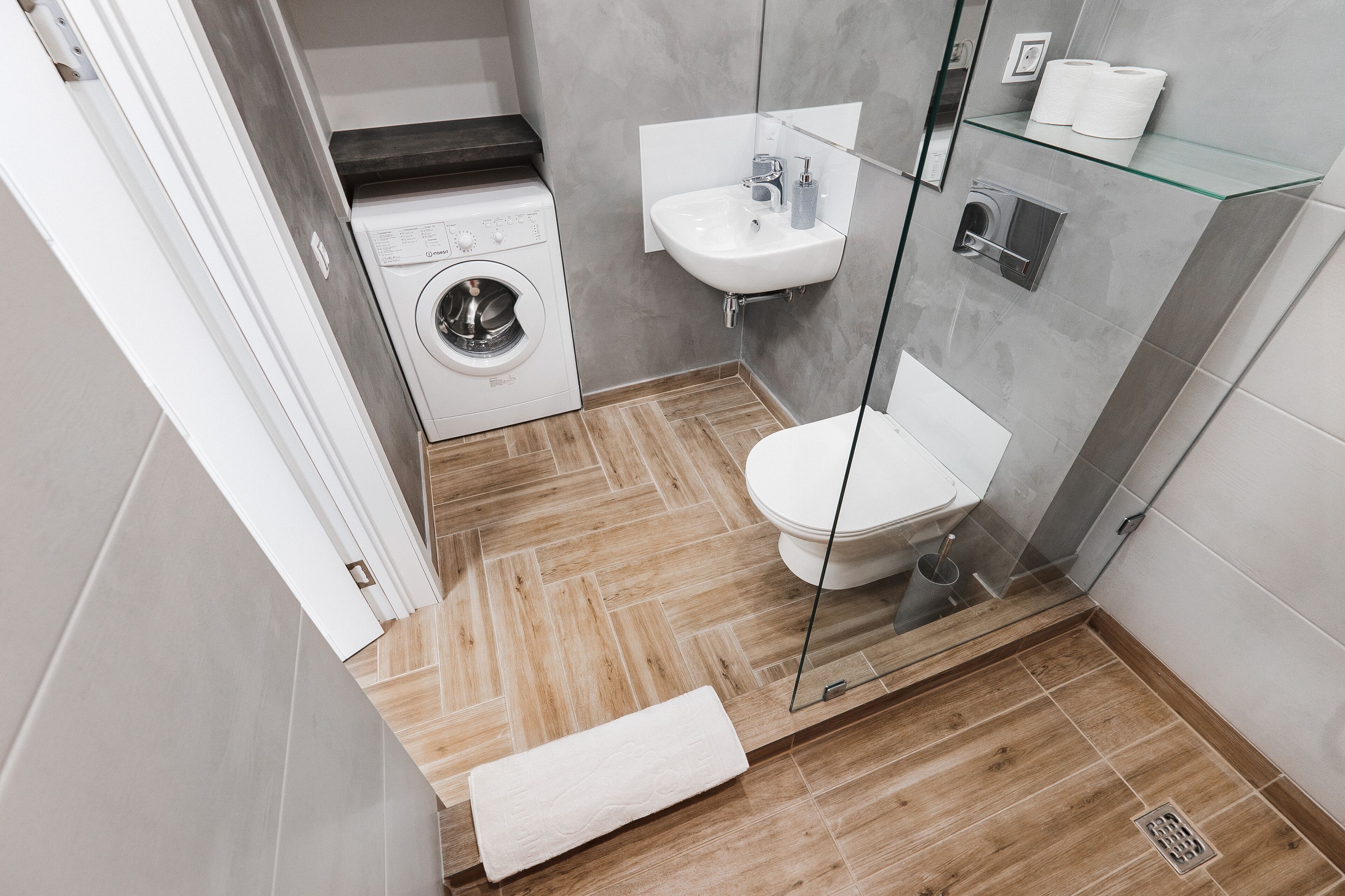 Une salle de bain moderne équipée d’un lave-linge, d’un évier et de toilettes.