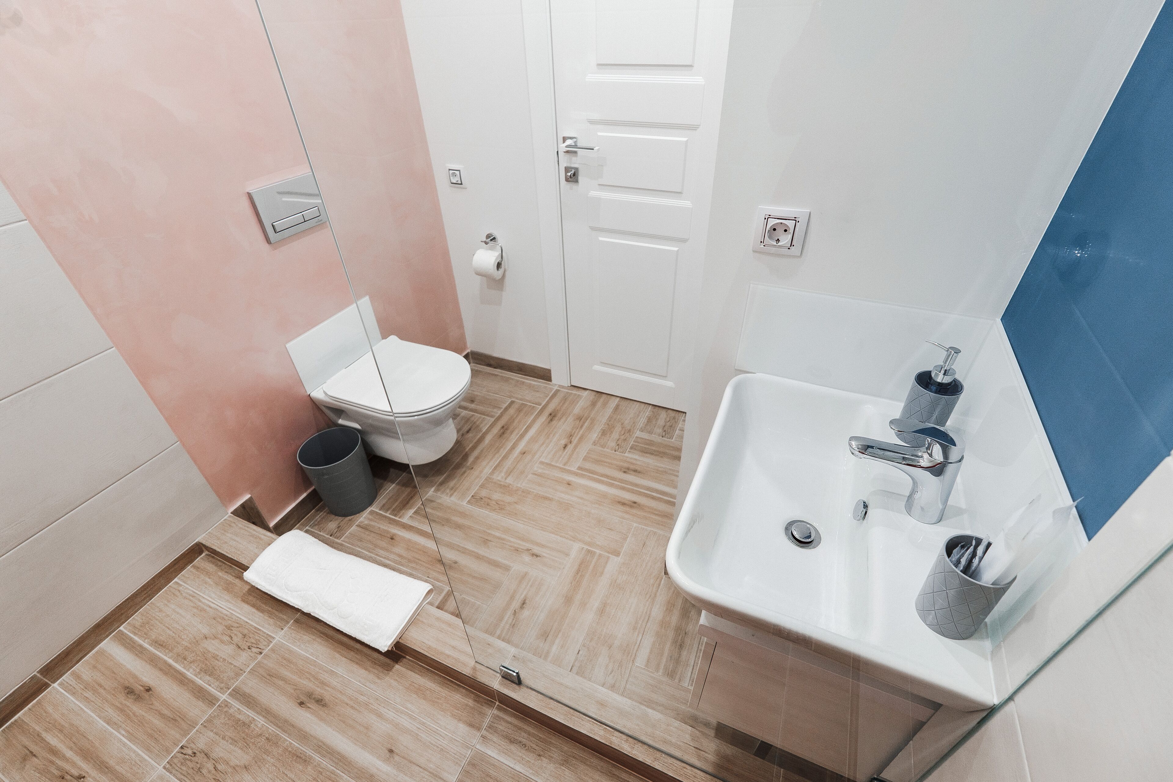 A modern bathroom with a toilet, sink, and mirror.