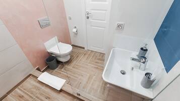 A modern bathroom with a toilet, sink, and mirror.