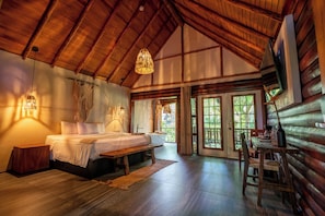 A log cabin interior with a bed, a table, and a view of the outdoors. -  Samao Resort (La Laguna)