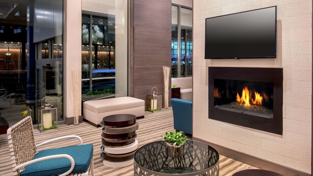 Un área de estar moderna con chimenea, asientos cómodos y un televisor de pantalla plana.
