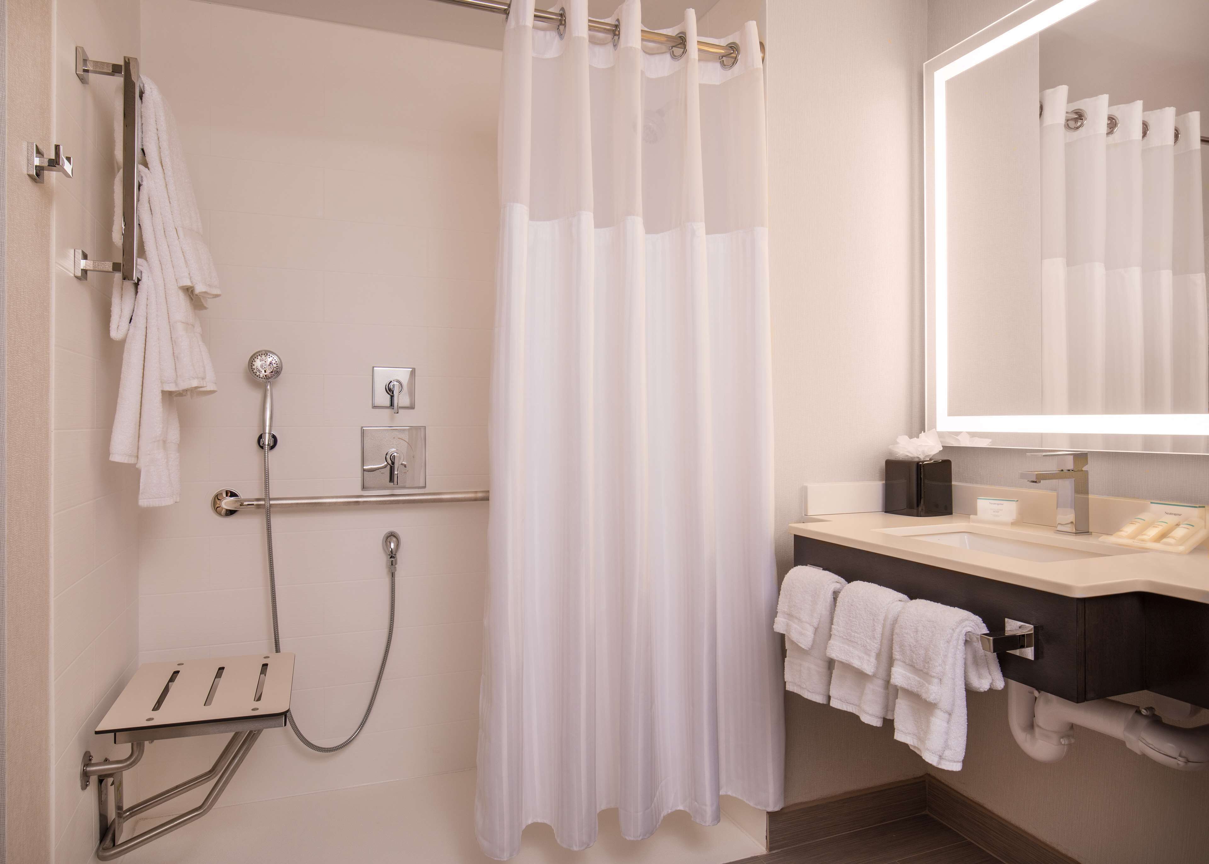 A modern bathroom with a shower, a toilet, and a sink.