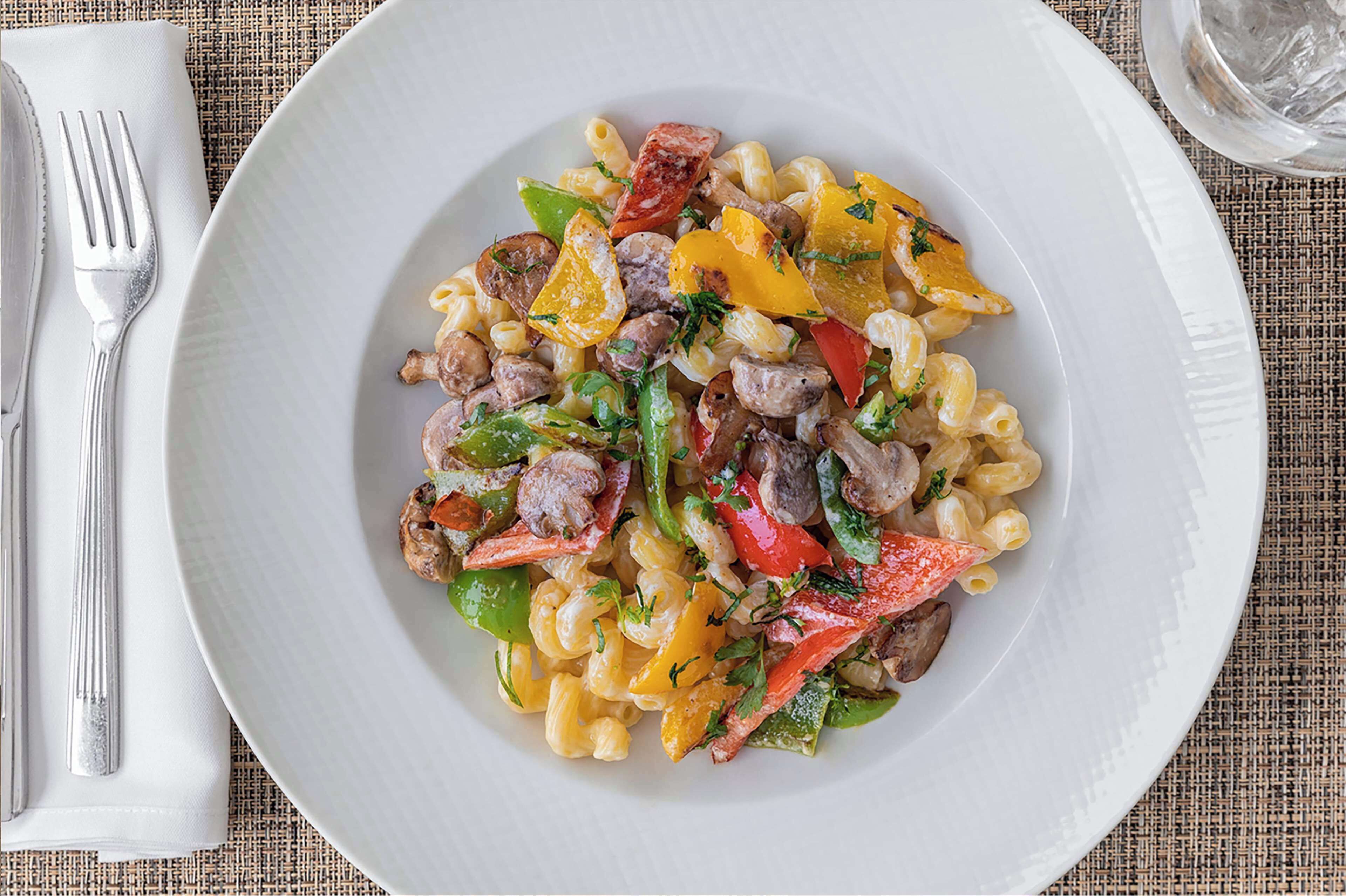 A plate of pasta with vegetables and meat.