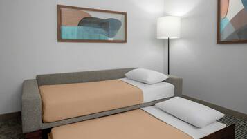 Una habitación de hotel moderna con una cama, una lámpara de pie y arte abstracto en las paredes.