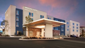 Un hôtel moderne doté d’une entrée imposante, portant l’inscription « SPRINGHILL SUITES MARRIOTT », et comprenant un passage couvert et un parking.