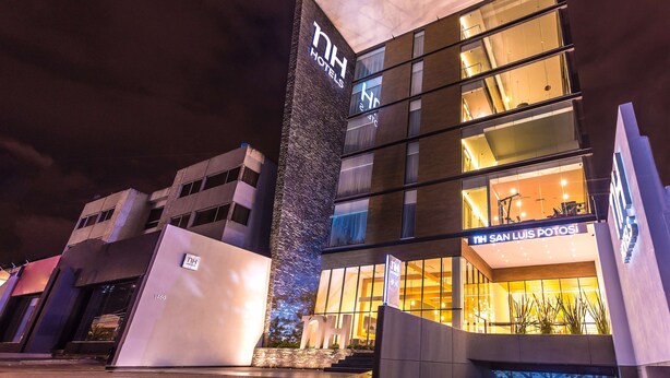 A modern hotel building with a prominent 'NH Hotels' sign, a 'San Luis Potosi' sign, and a large glass entrance. - NH San Luis Potosi (San Luis Potosi)