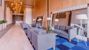 A modern hotel lobby with sofas, a coffee table, and a mirror. - NH San Luis Potosi (San Luis Potosi)