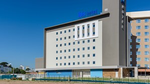 Un bâtiment d’hôtel moderne avec une enseigne indiquant « ibis budget hotel » sur la façade.
