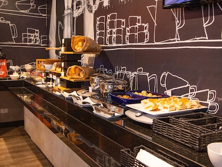A buffet setup with various food items and kitchen equipment.