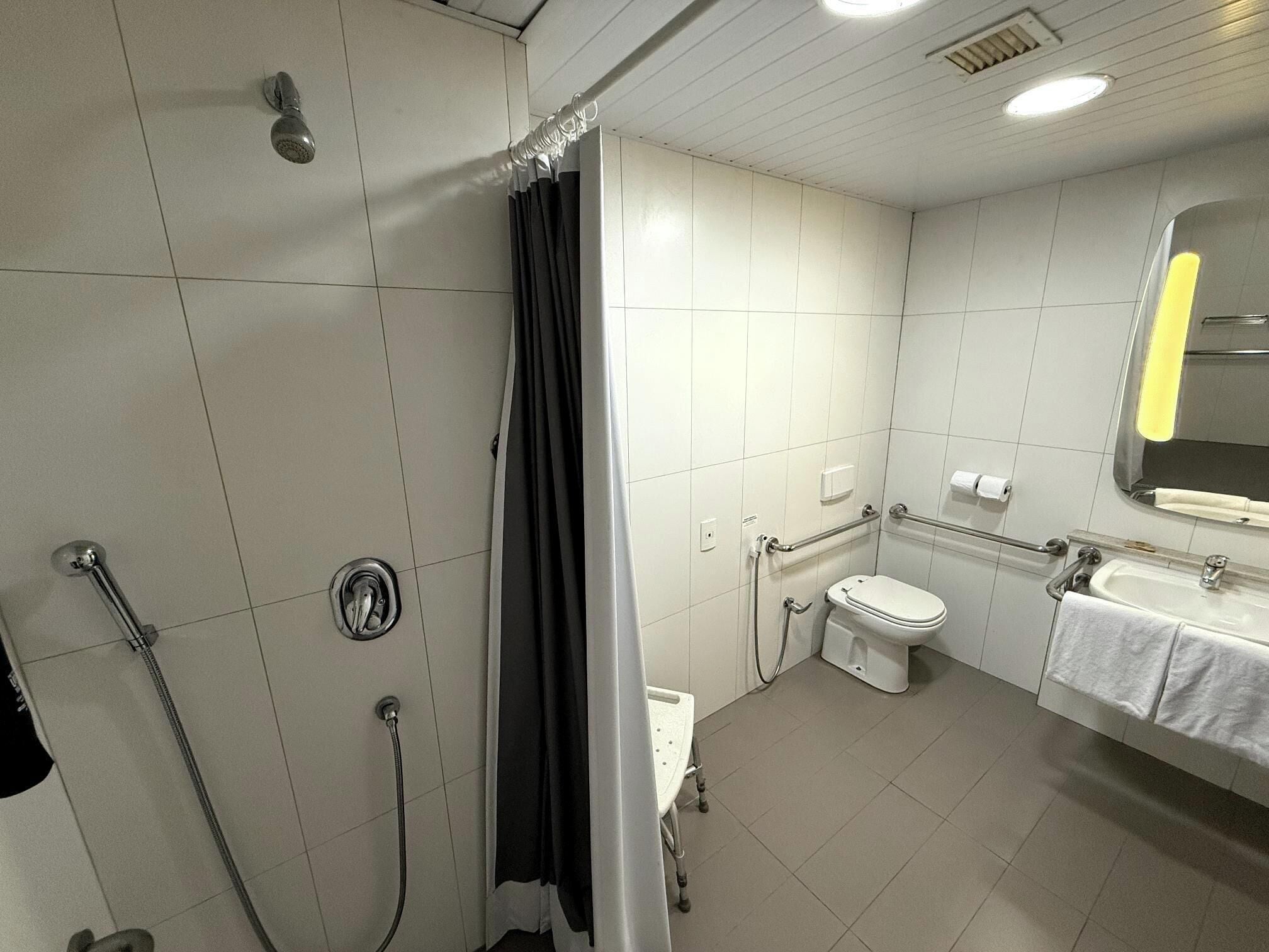 Une salle de bain avec douche, toilettes et lavabo.