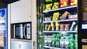 Un distributeur automatique proposant des collations et des boissons, notamment des chips et des sodas.