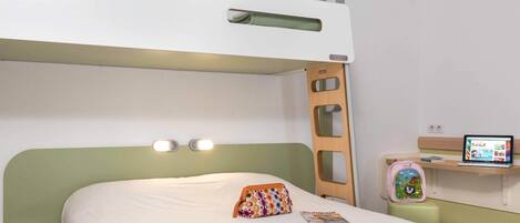 A bunk bed room with a laptop on a desk, a colorful bag, and a magazine on the bed.