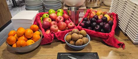 Une table de buffet avec divers fruits et un couteau sur une planche à découper.