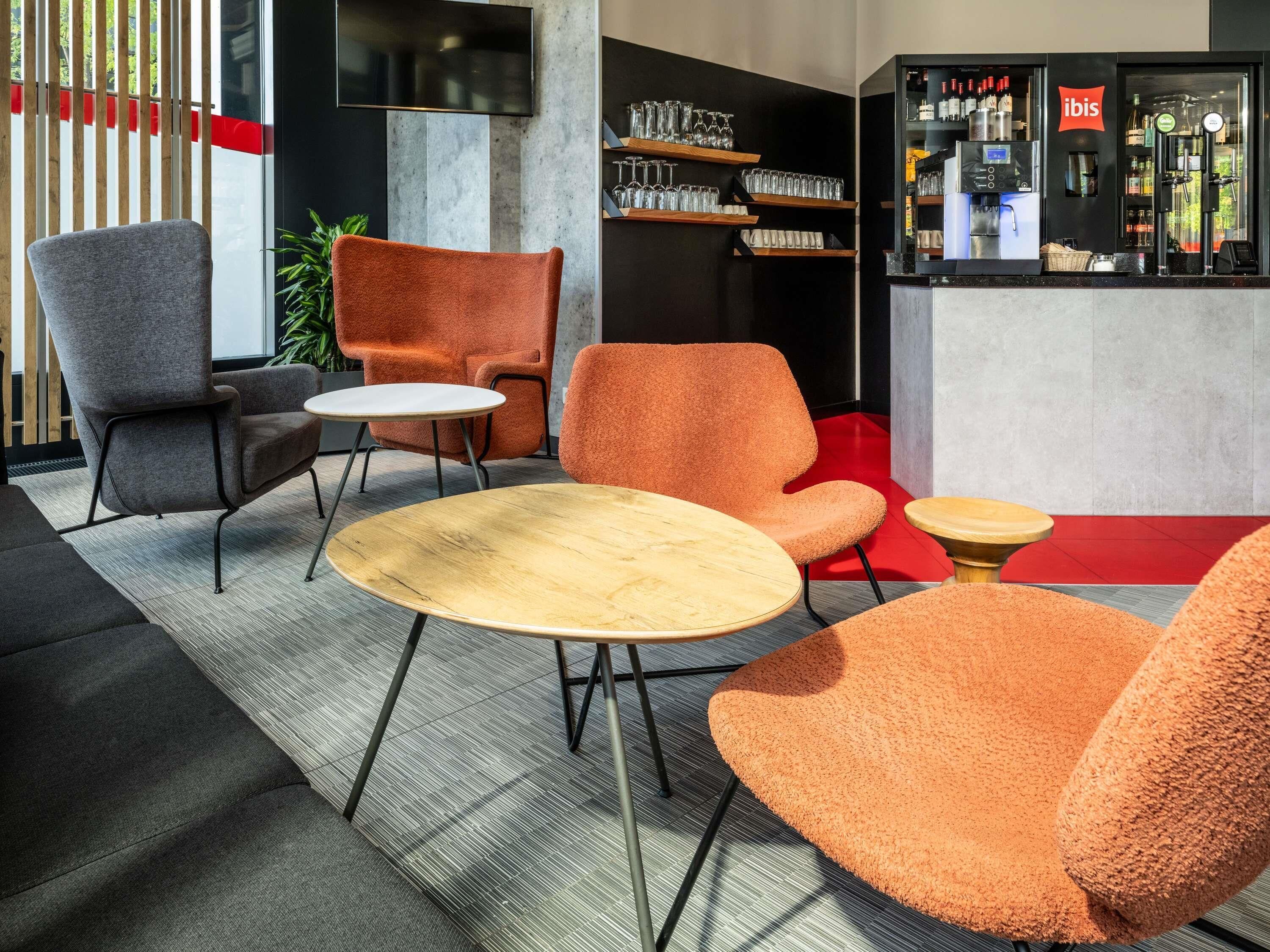 Een moderne lounge met een bar, zitplaatsen en een televisie.