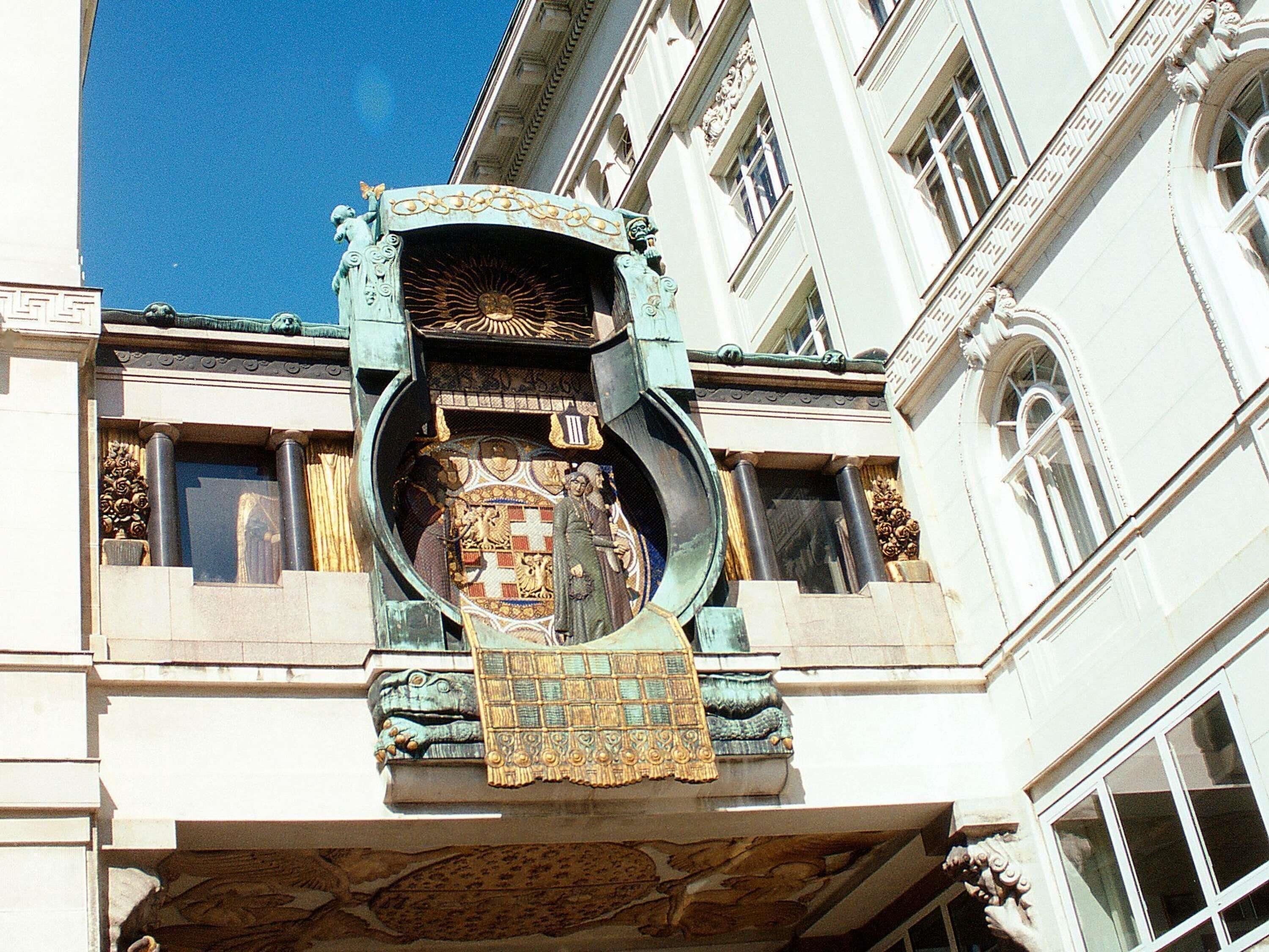 A building facade with ornate architectural details, including a decorative balcony and a large circular window.