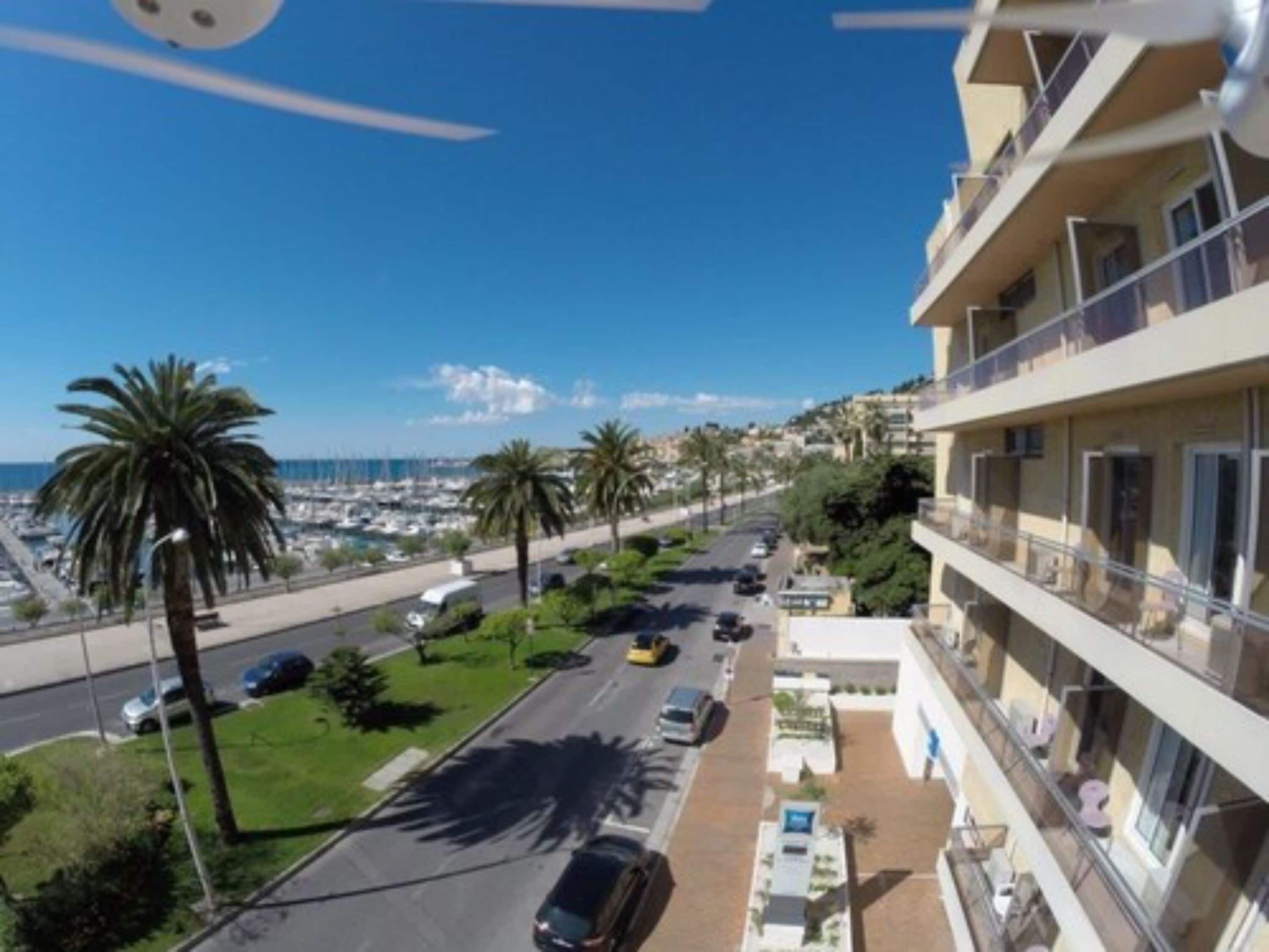 A coastal hotel with a view of the marina and palm trees.