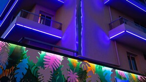 A multi-story building with balconies and a brightly lit facade. - ibis budget Menton (Menton)