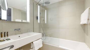 A modern bathroom with a glass-enclosed shower, a white sink, and a bathtub.