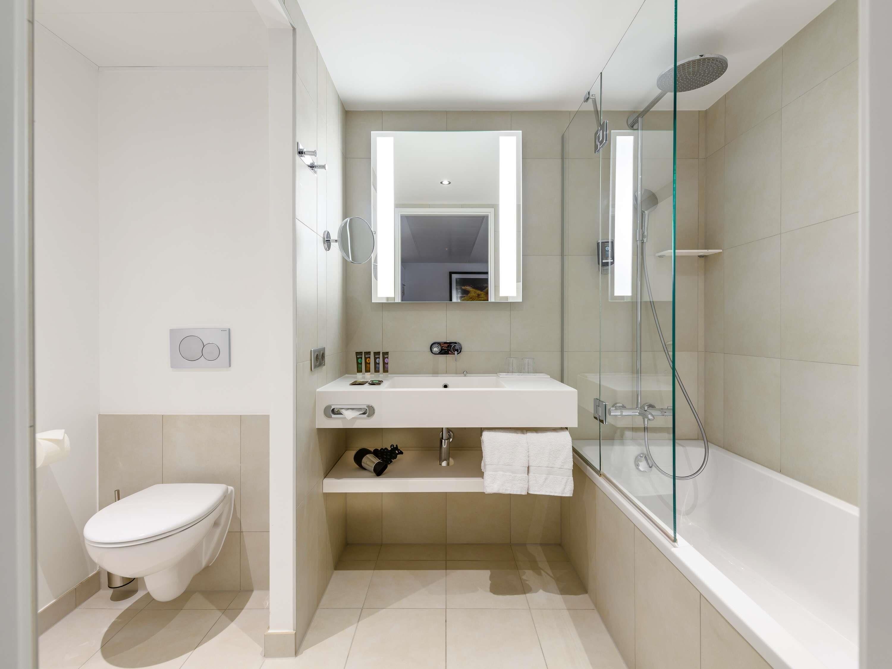 Un bagno moderno con WC, lavandino e cabina doccia in vetro.