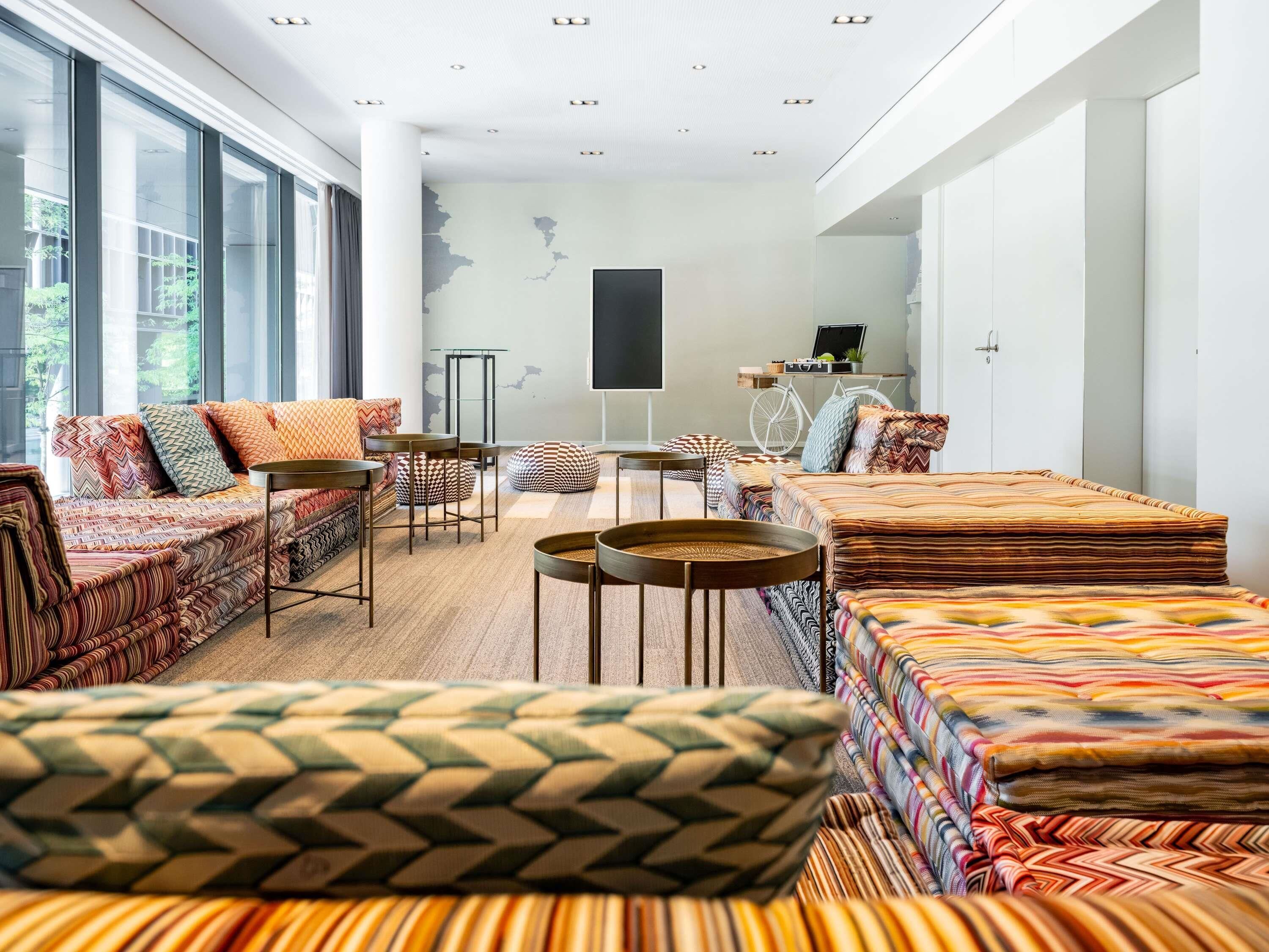 Una sala de estar moderna con un sofá, sillas y una mesa de centro.