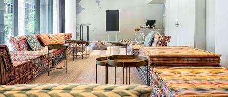Una sala de estar moderna con un sofá, sillas y una mesa de centro.