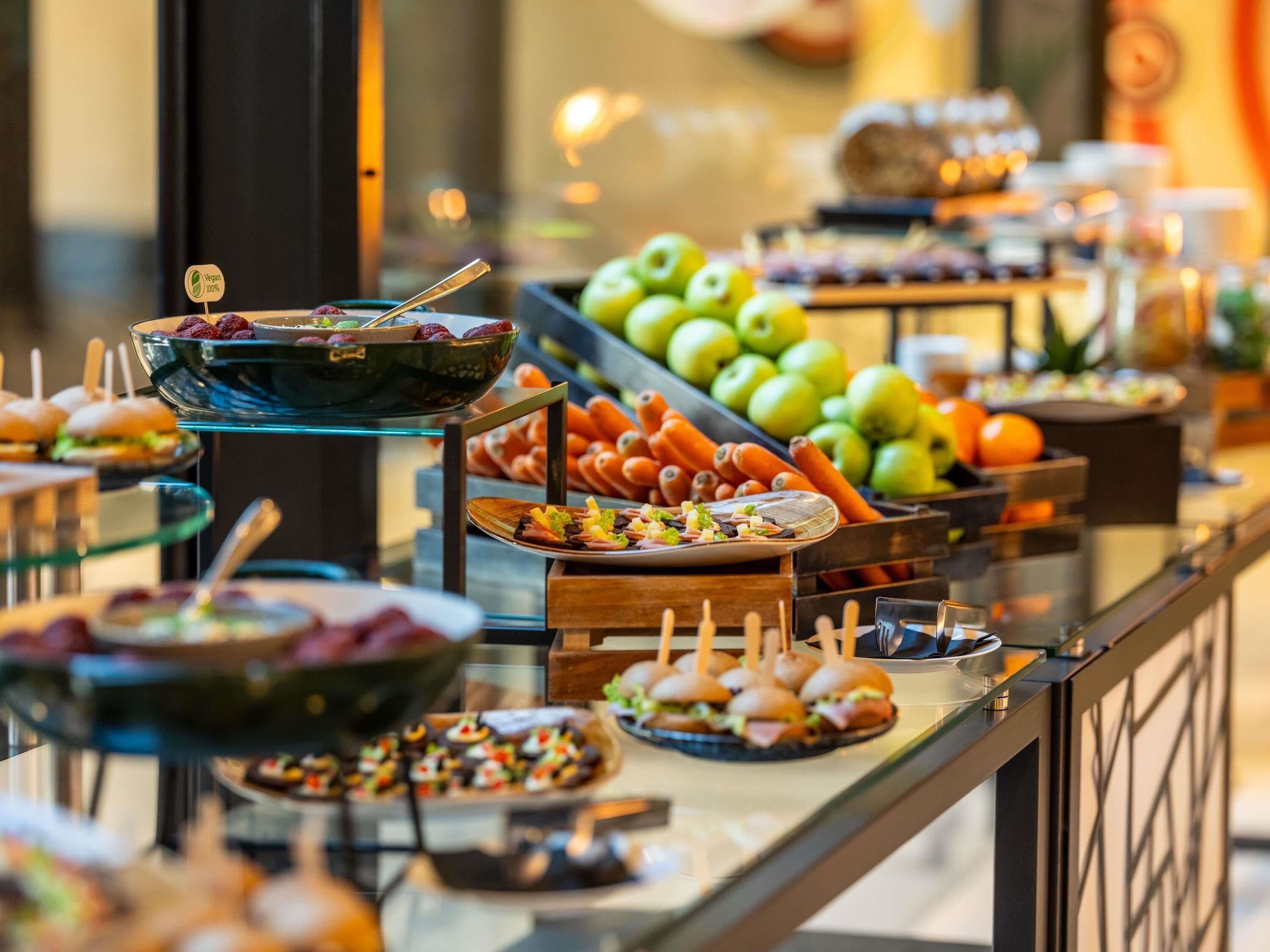 Buffet com diversos alimentos, incluindo frutas, legumes e pratos prontos.