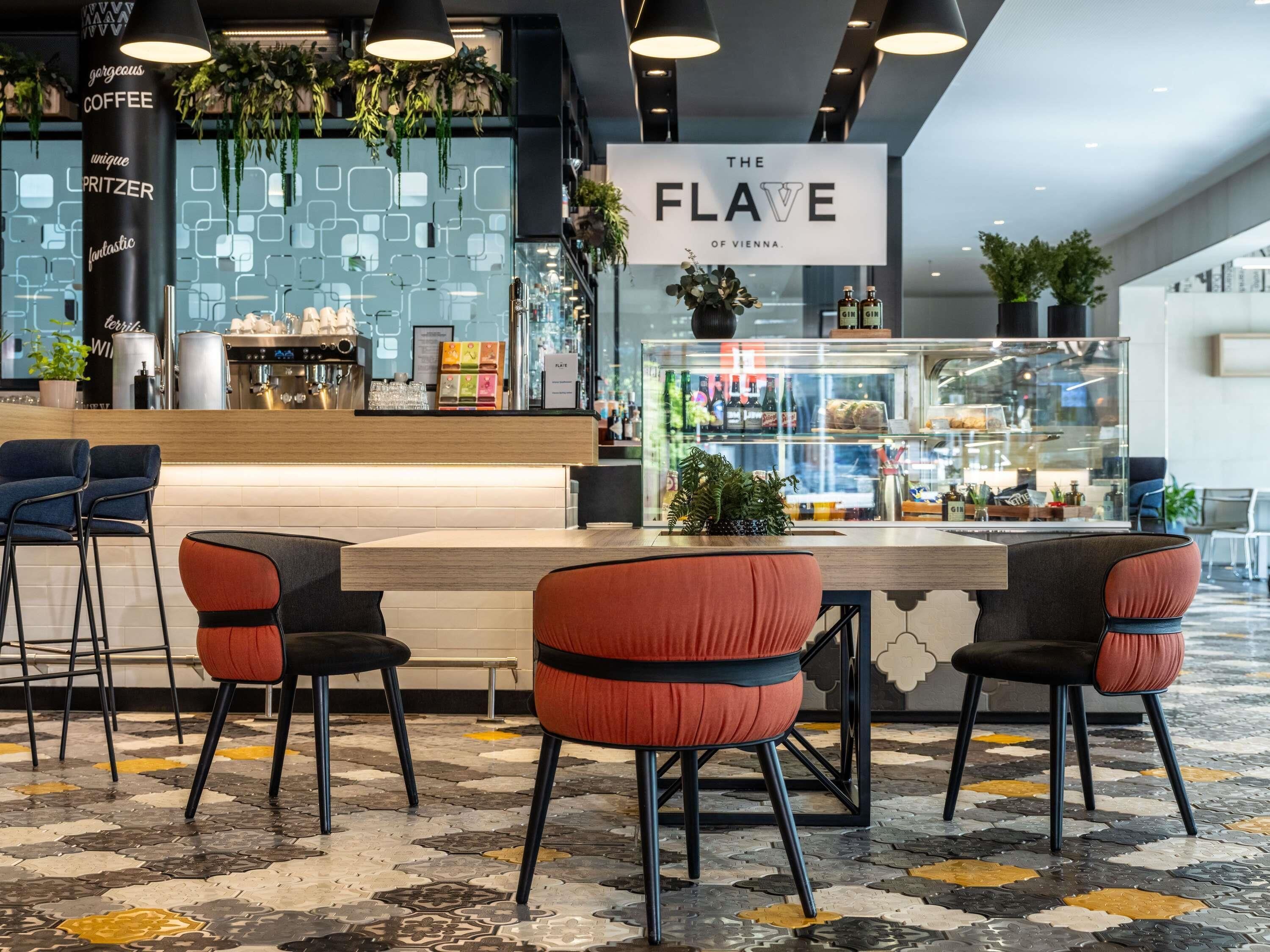 Un área de bar moderna con una barra, taburetes y un cartel que dice 'The Flave of Vienna'.
