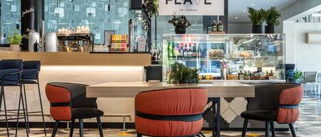 Un área de bar moderna con una barra, taburetes y un cartel que dice 'The Flave of Vienna'.