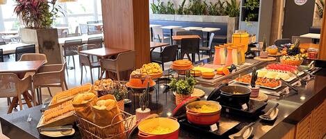 A buffet setup with various food items and a modern interior design.