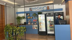 A self-service beverage station with refrigerated drink dispensers and a variety of snacks and beverages on shelves.